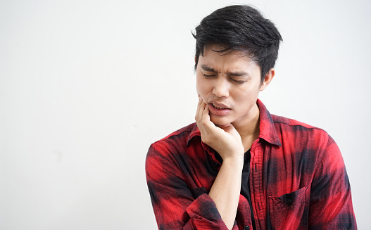 man holding jaw having pain after car accident