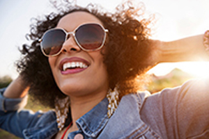 beautiful woman in sunshine smiling with sunglasses